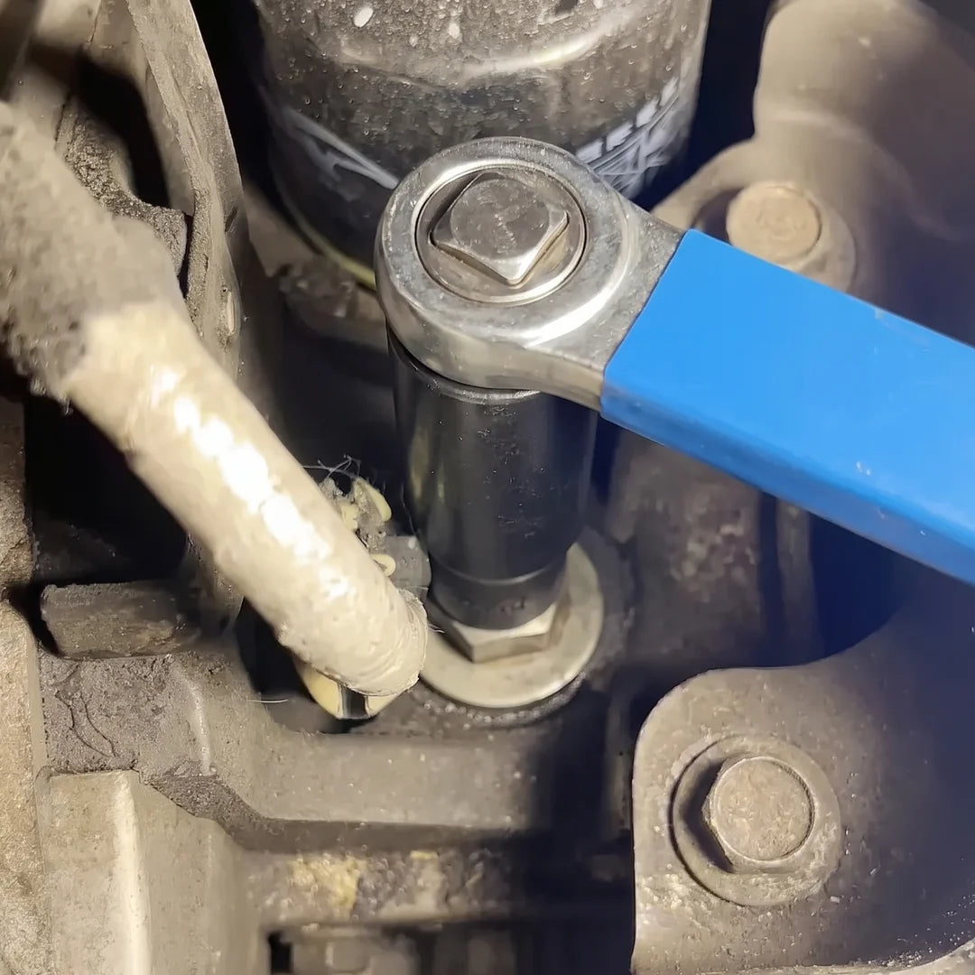 A hand guiding the bar onto a buried bolt